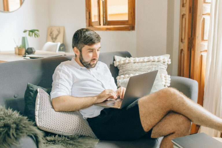 man on his sofa with a laptop